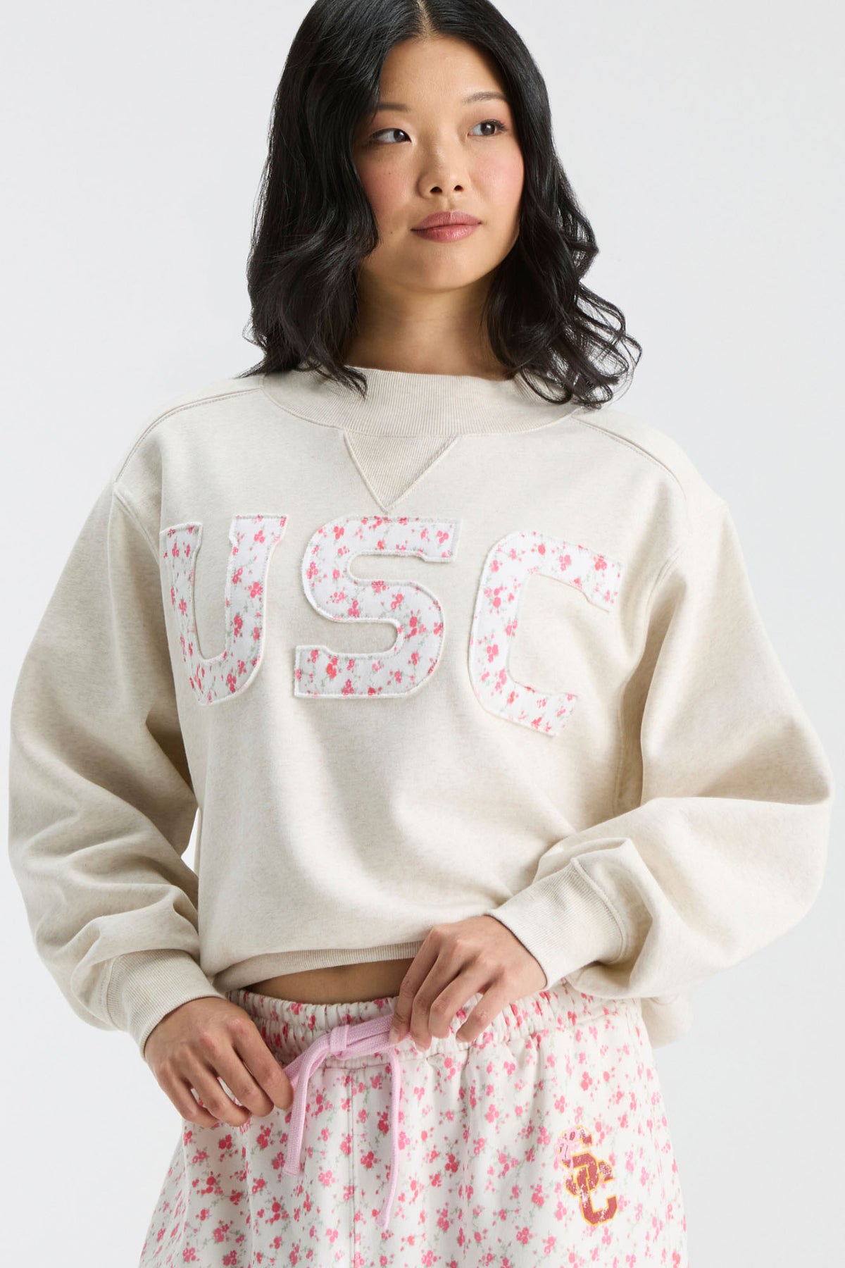 Cream mockneck crew sweatshirt front view with pink floral “U S C” letters