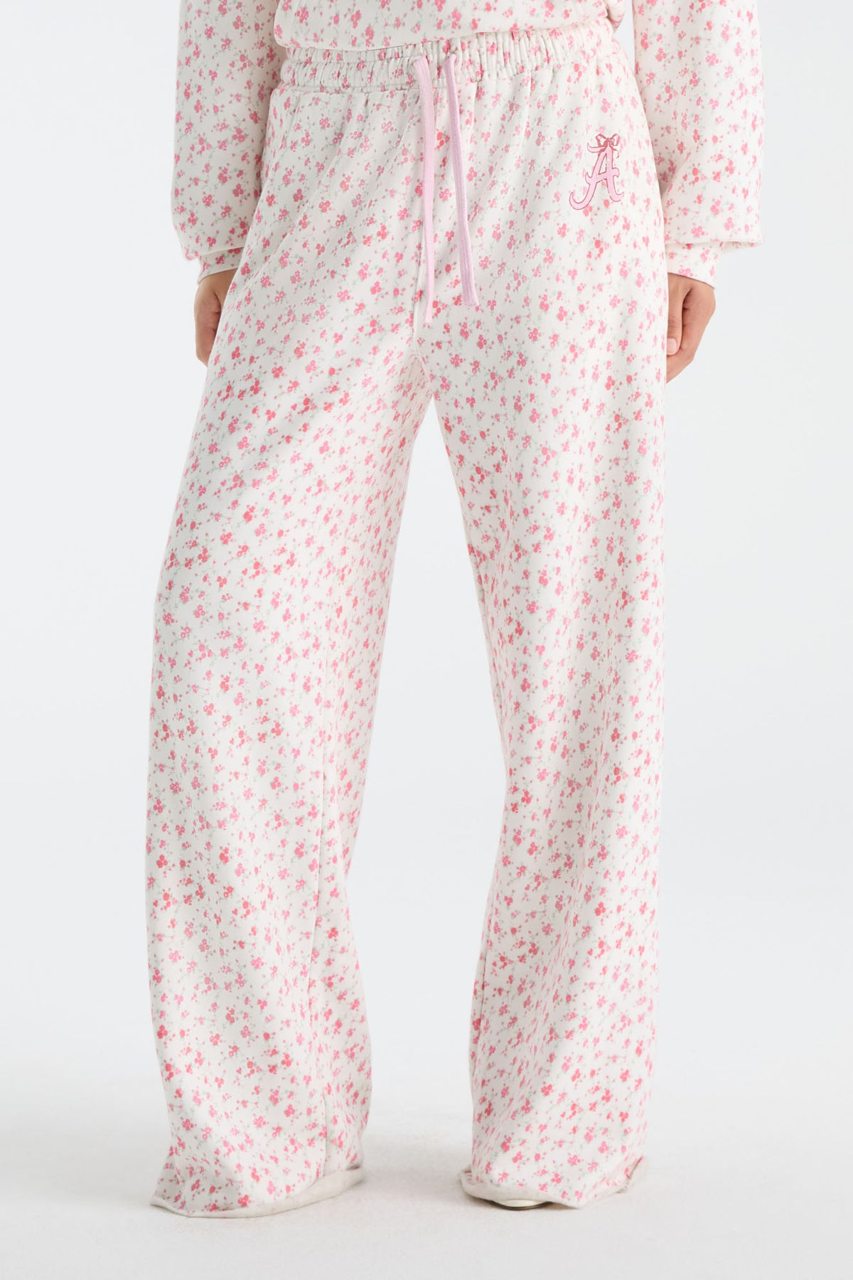 Cream sweatpants with pink floral print and drawstring waist, full leg view