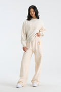 Cream floral sweatpants with orange mascot-style graphic and elastic waist