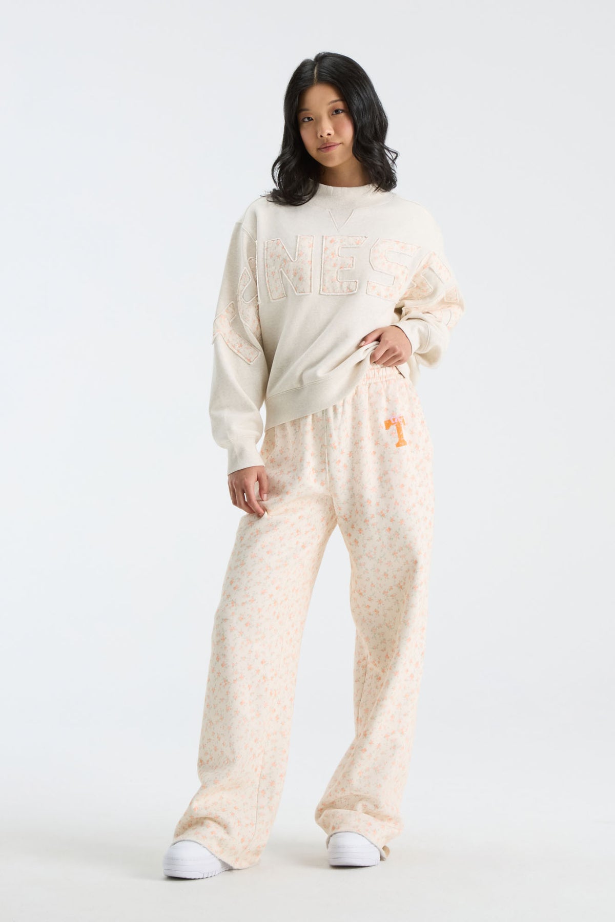 Cream floral sweatpants with orange mascot-style graphic and elastic waist