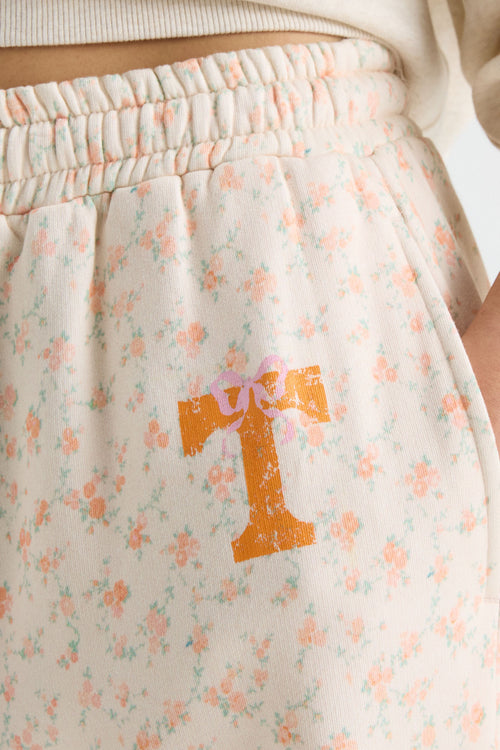Close-up of cream sweatpants waistband with elastic and orange number graphic