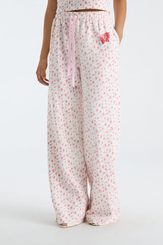 Side view of women’s wide-leg sweatpants with pink drawstring and scattered floral print