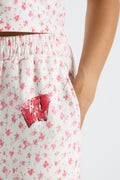 Close-up of women’s pale floral sweatpants with Texas graphic on the back waistband area