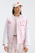 Pink floral baseball cap with small red print and matching varsity-style jacket