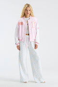 Pink varsity jacket with letterman patches and button front, worn over pajama-style set