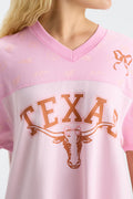 Pink V-neck jersey dress close-up with Texas longhorn graphic and bow