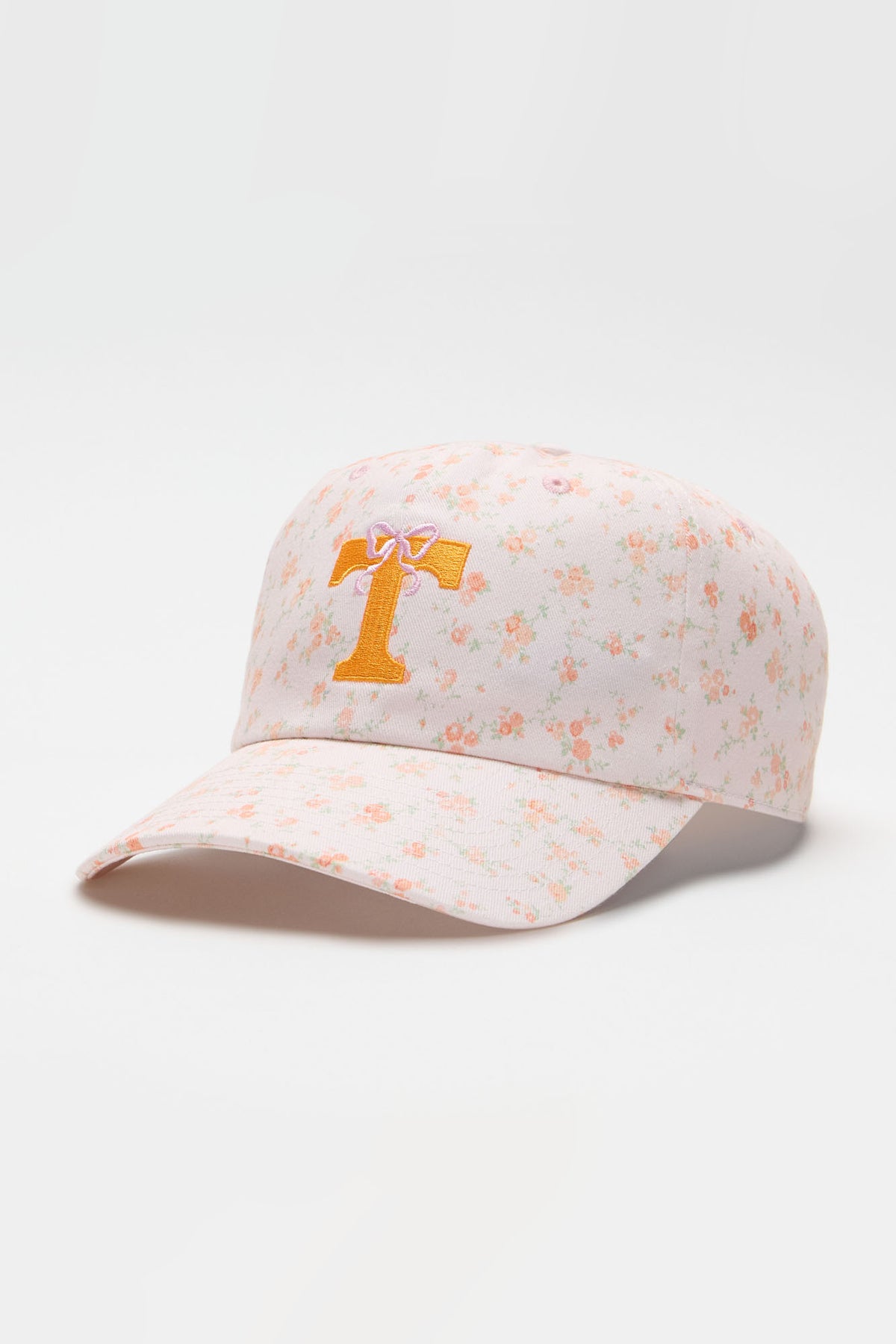 Light pink floral baseball cap with orange letter graphic on the front panel
