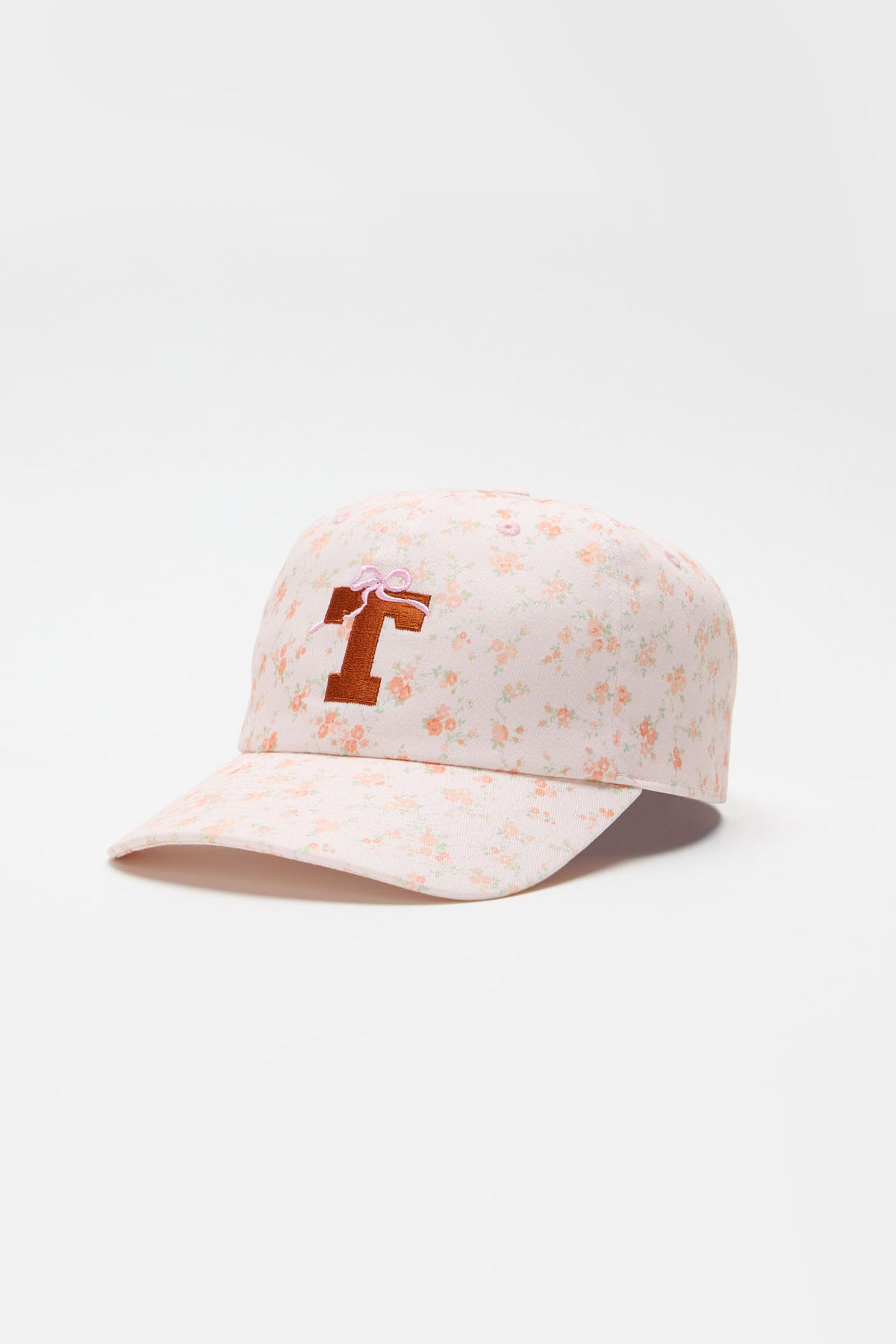 Light pink floral baseball cap with orange letter graphic on the front