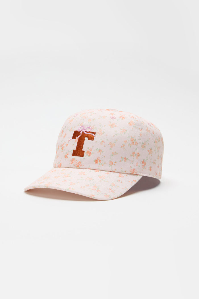 Light pink floral baseball cap with orange letter graphic on the front