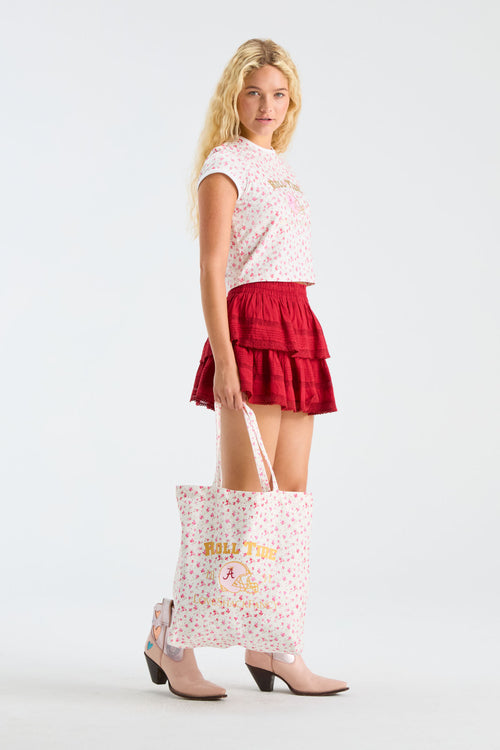 Pink patterned tote bag with printed logo text and top handles