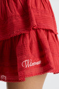 Dark red tiered ruffle mini skirt with lace-trimmed hem and embroidered logo patch