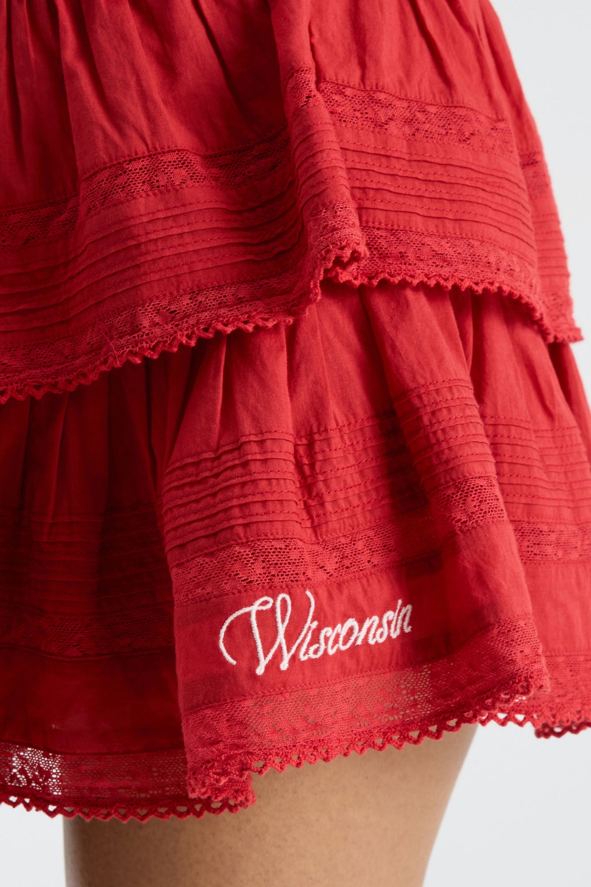 Dark red tiered ruffle mini skirt with lace-trimmed hem and embroidered logo patch