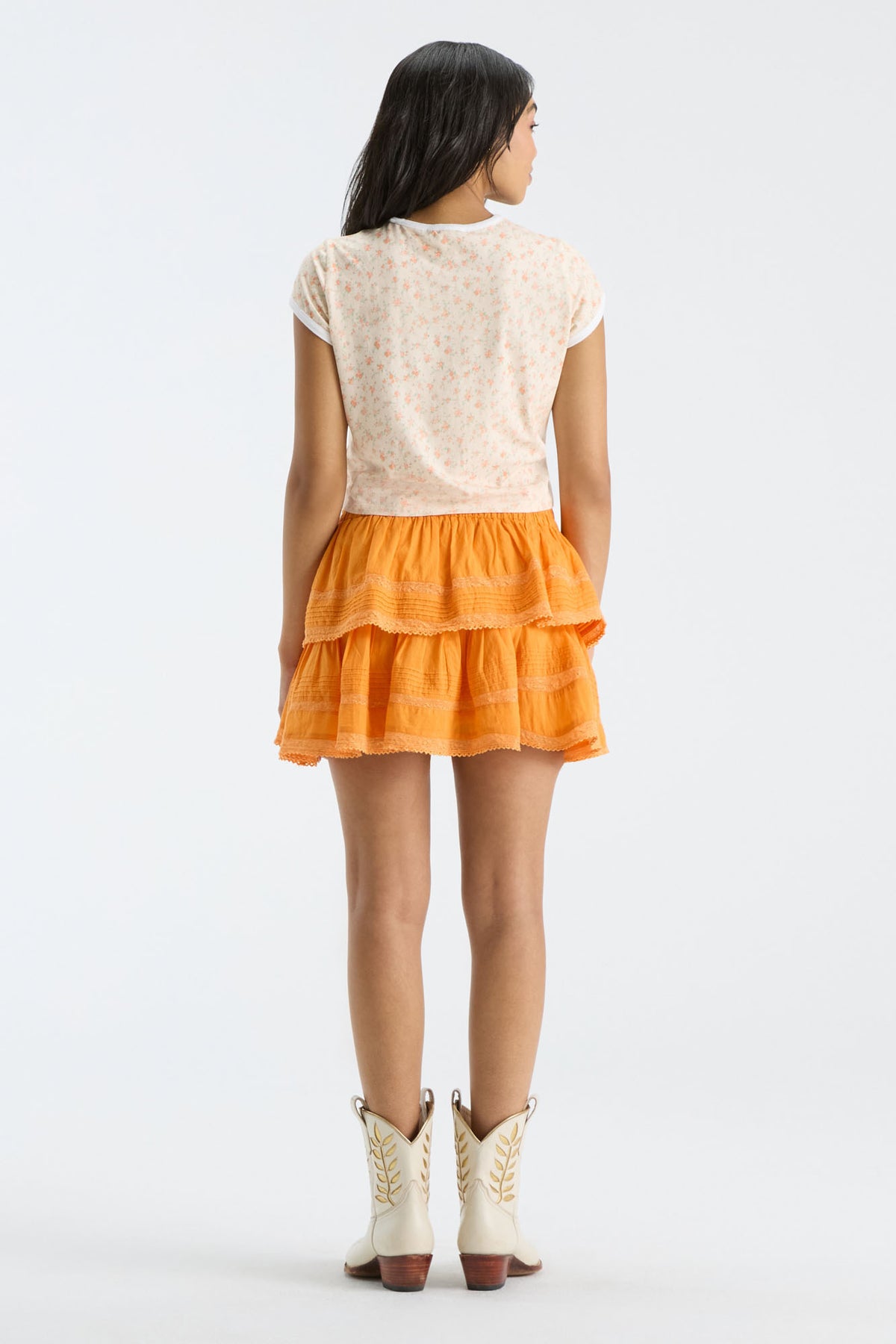 Bright orange tiered ruffle mini skirt, elastic waistband, back view