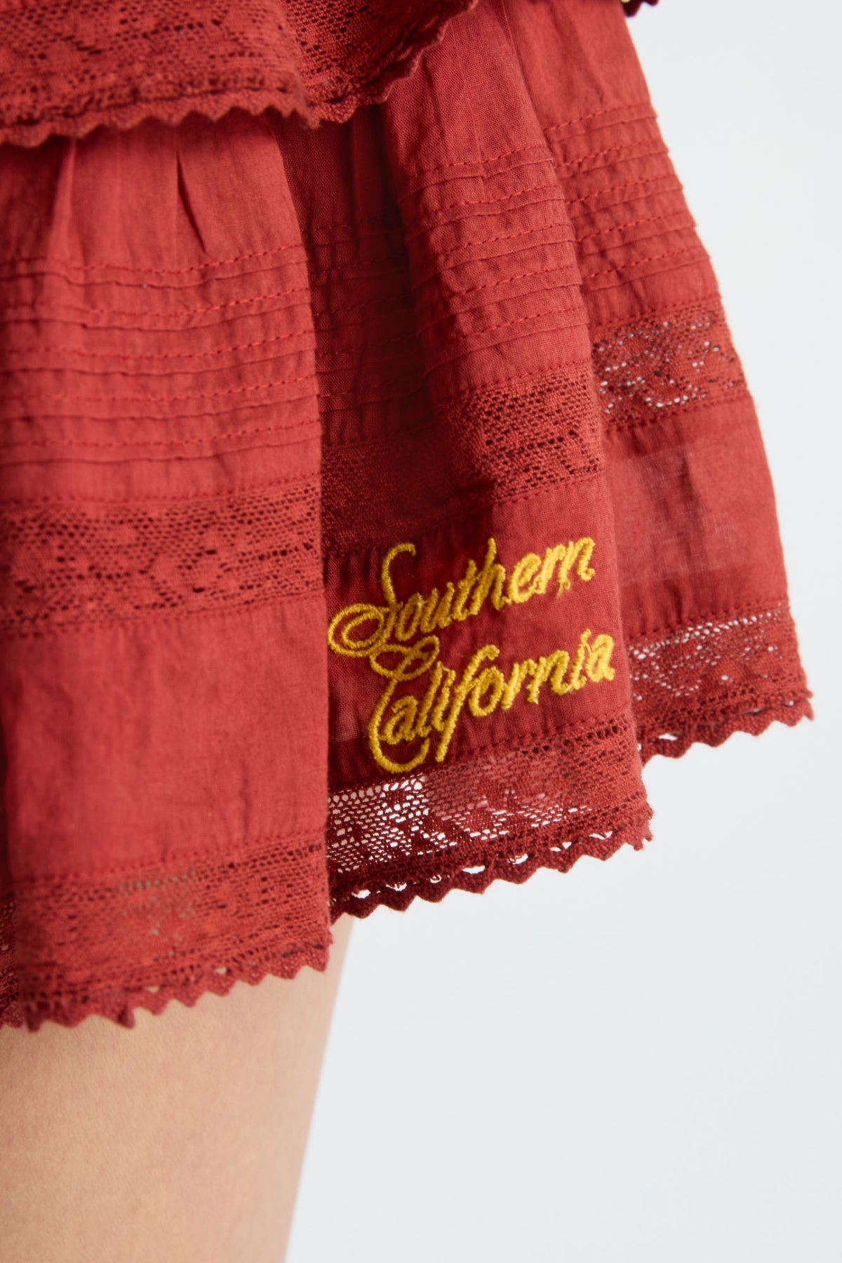 Red mini skirt with tiered ruffles and gold “Southern California” embroidery