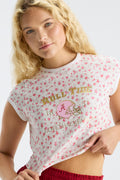 Close-up: pink floral ringer tee with gold “ROLL TIDE” text and helmet graphic