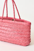 Mini woven tote bag close-up with pink braided handles and open top