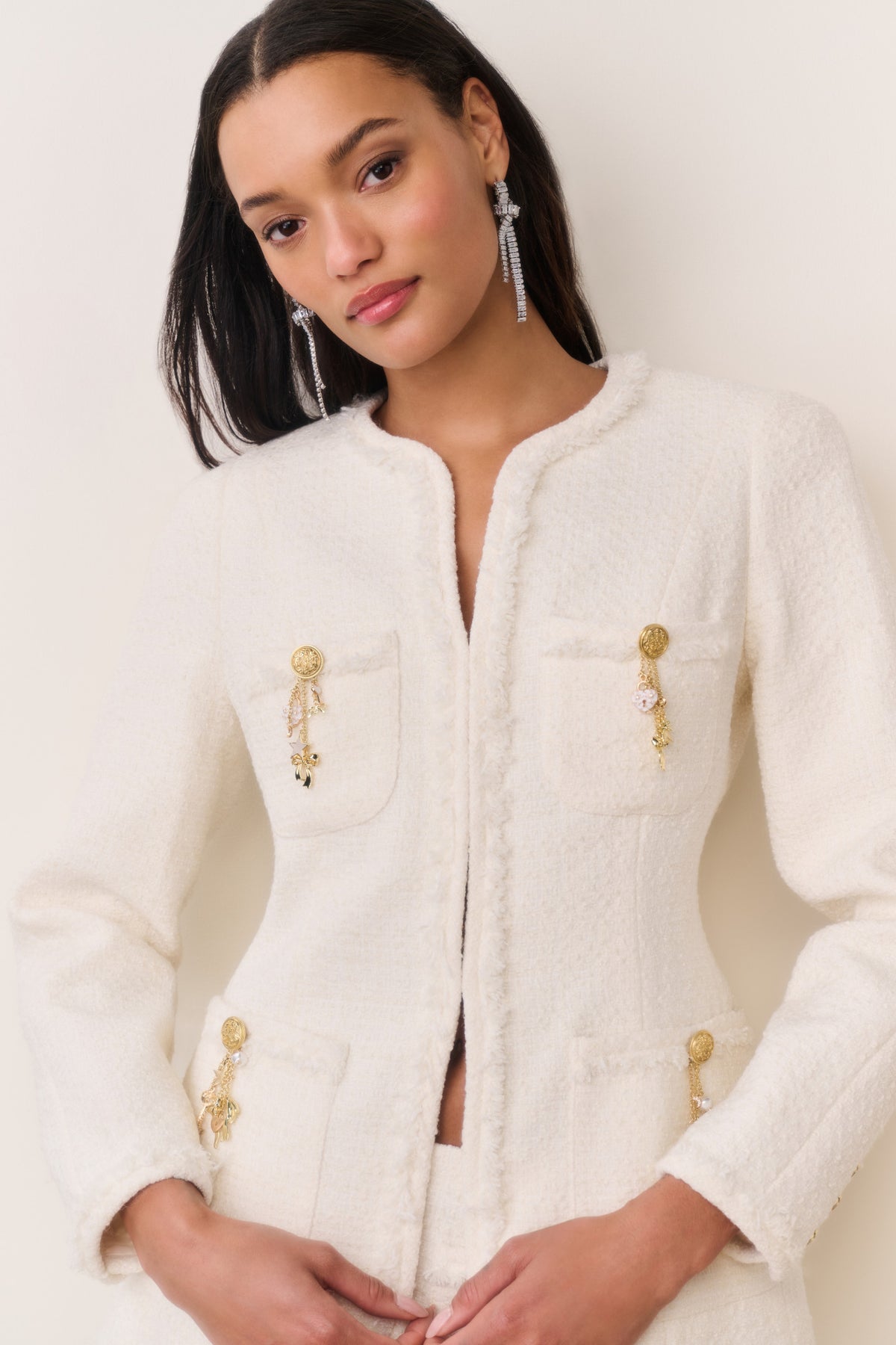 Cream tweed jacket with zipper front, gold-tone charm embellishments, patch flap pockets