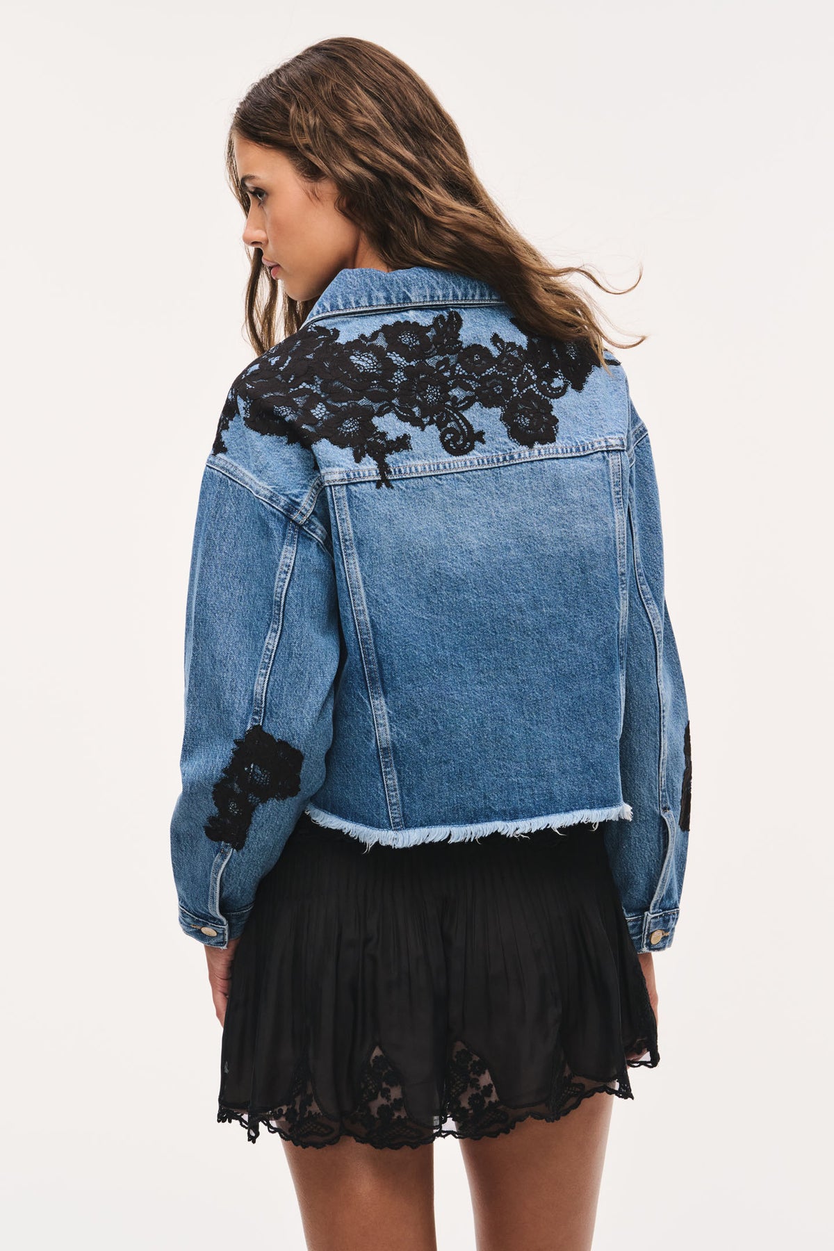 Lace appliqué denim jacket with black floral lace on the back yoke and sleeves