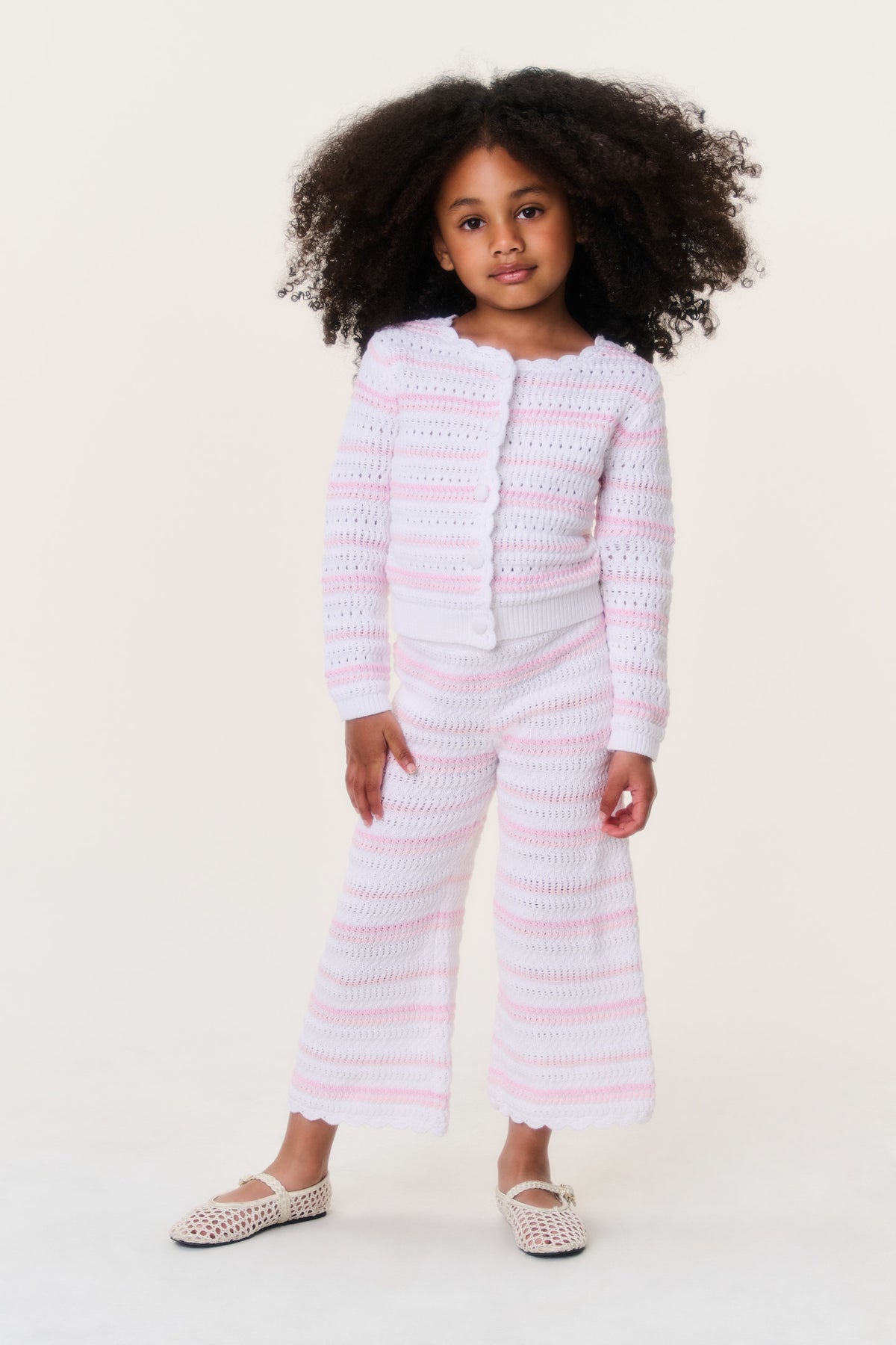 Girls crochet cardigan with pink-and-white horizontal stripes, button front, scalloped edges.