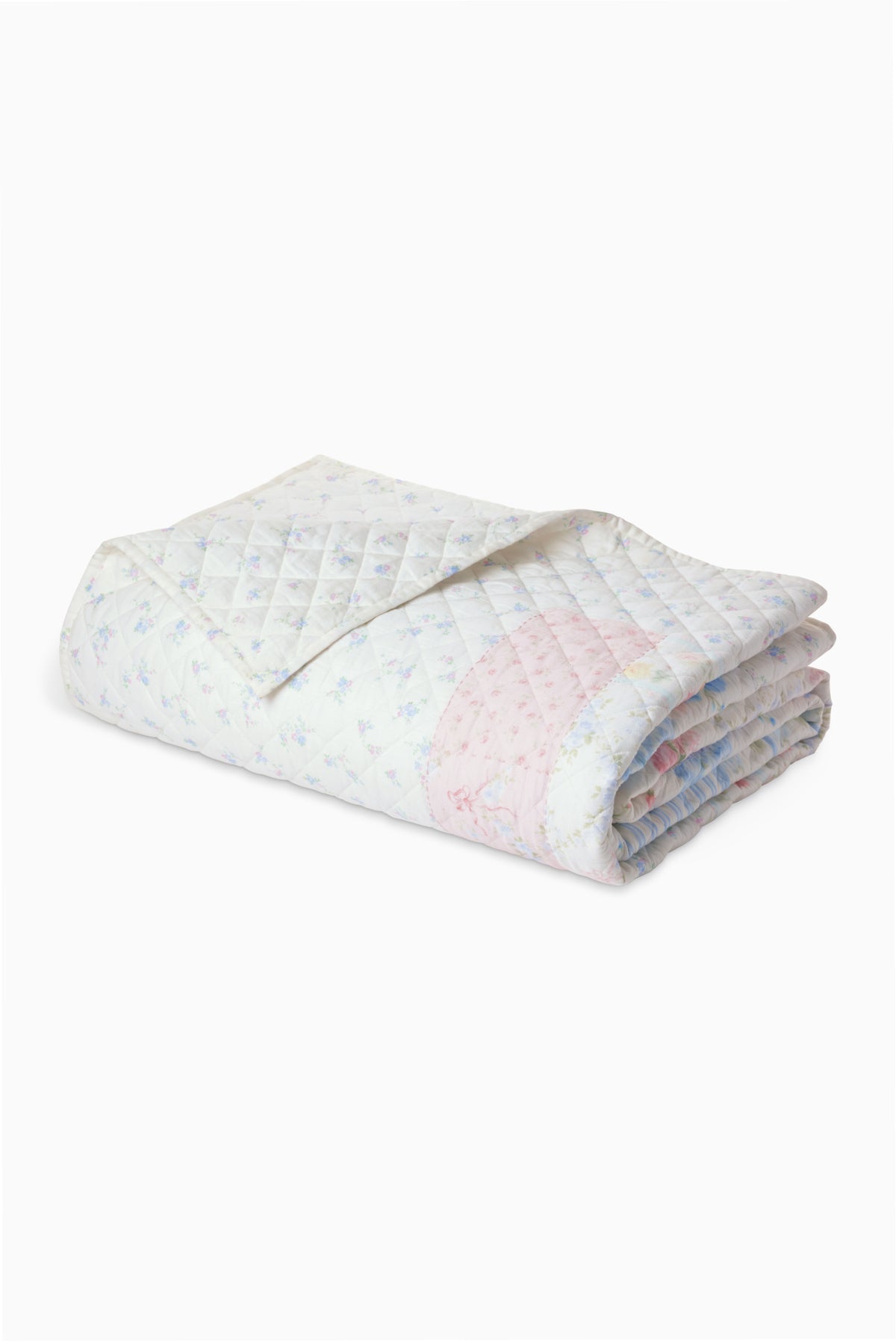 Light patchwork quilt with pale blue and pink floral blocks, rolled view