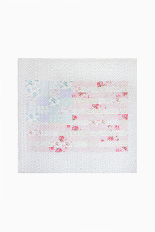 Light patchwork quilt with scattered pink and blue floral print, close-up