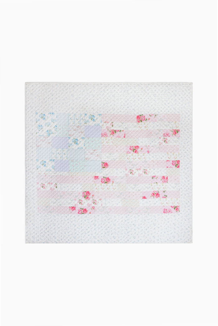 Light patchwork quilt with scattered pink and blue floral print, close-up
