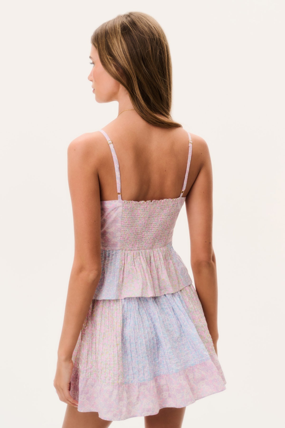 Back view of tiered spaghetti-strap mini dress in pink and blue floral print