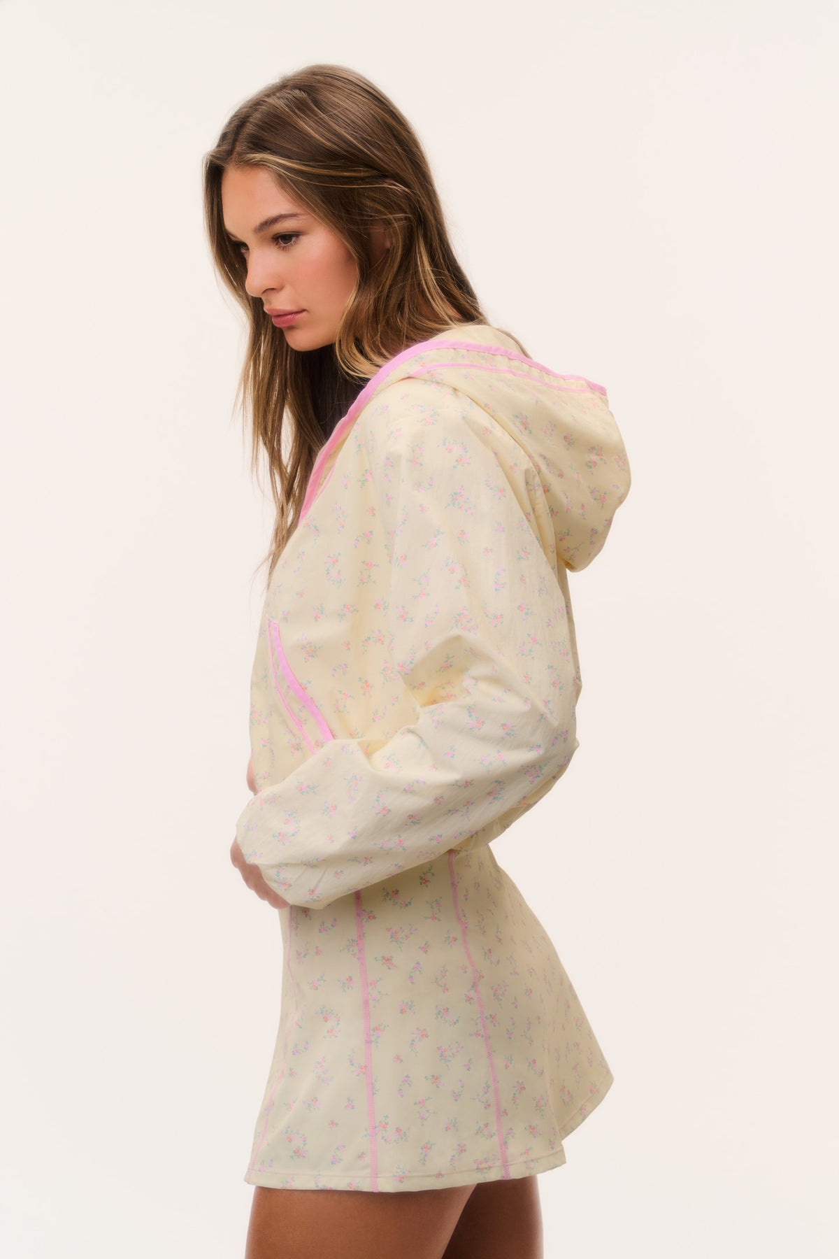 Cream windbreaker hoodie with pink piping and hood, side/back view