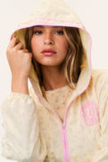Cream windbreaker hoodie with pink drawstring hood and pastel all-over print, close-up