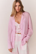 Pink cashmere cardigan layered over floral camisole with open button front