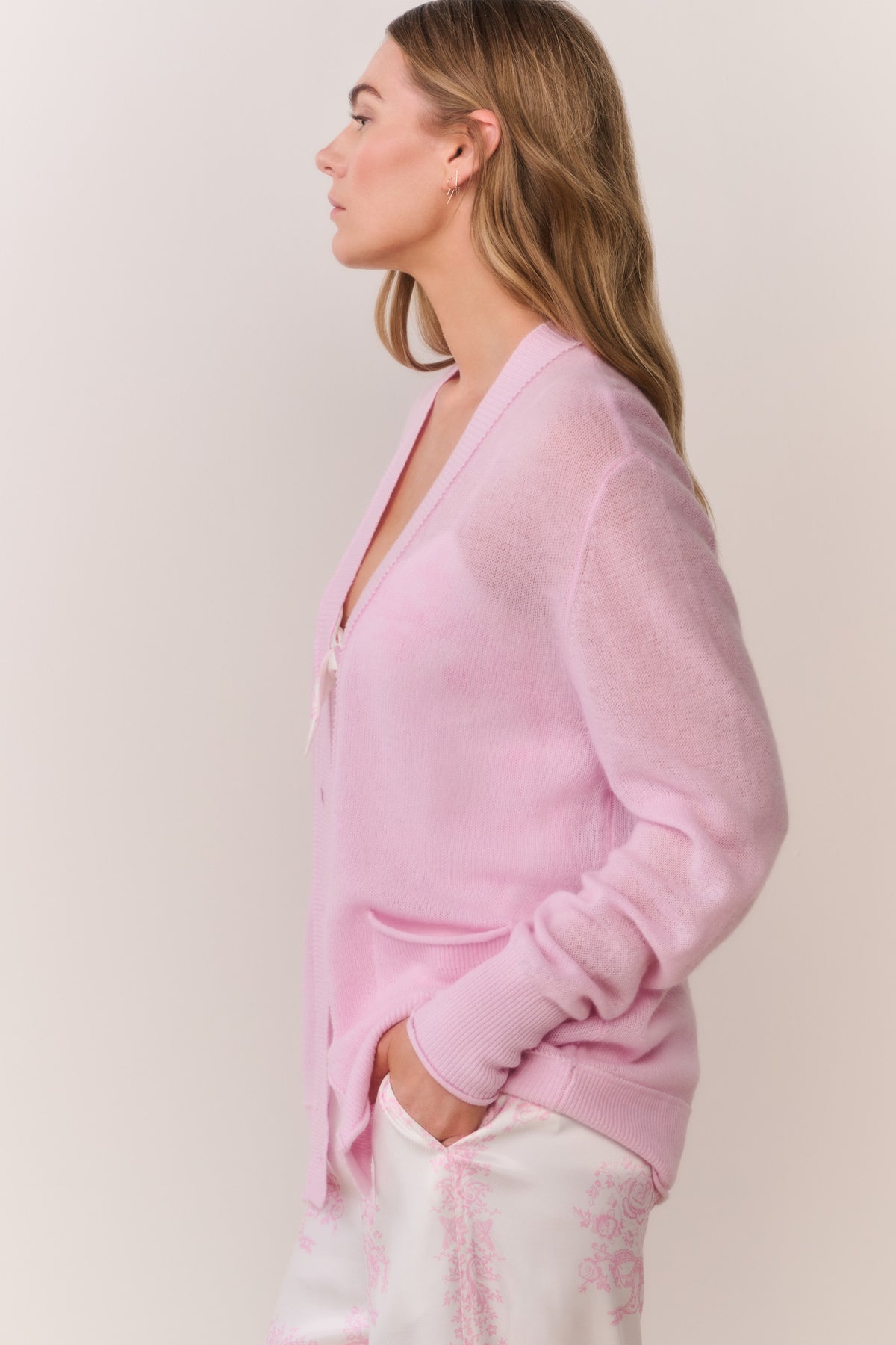 Pink cashmere cardigan with button front, patch pockets, and long sleeves