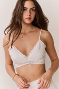 White lace bralette with V-neck, adjustable straps, sheer texture