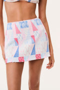 Patchwork print swim skirt in white with blue and pink tones, flared ruffle hem