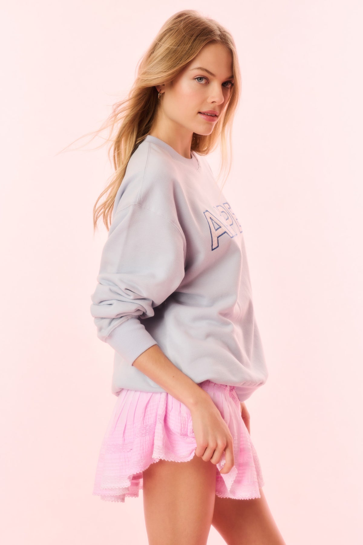 Light blue crewneck pullover sweatshirt with “ASPEN” graphic detail on sleeve