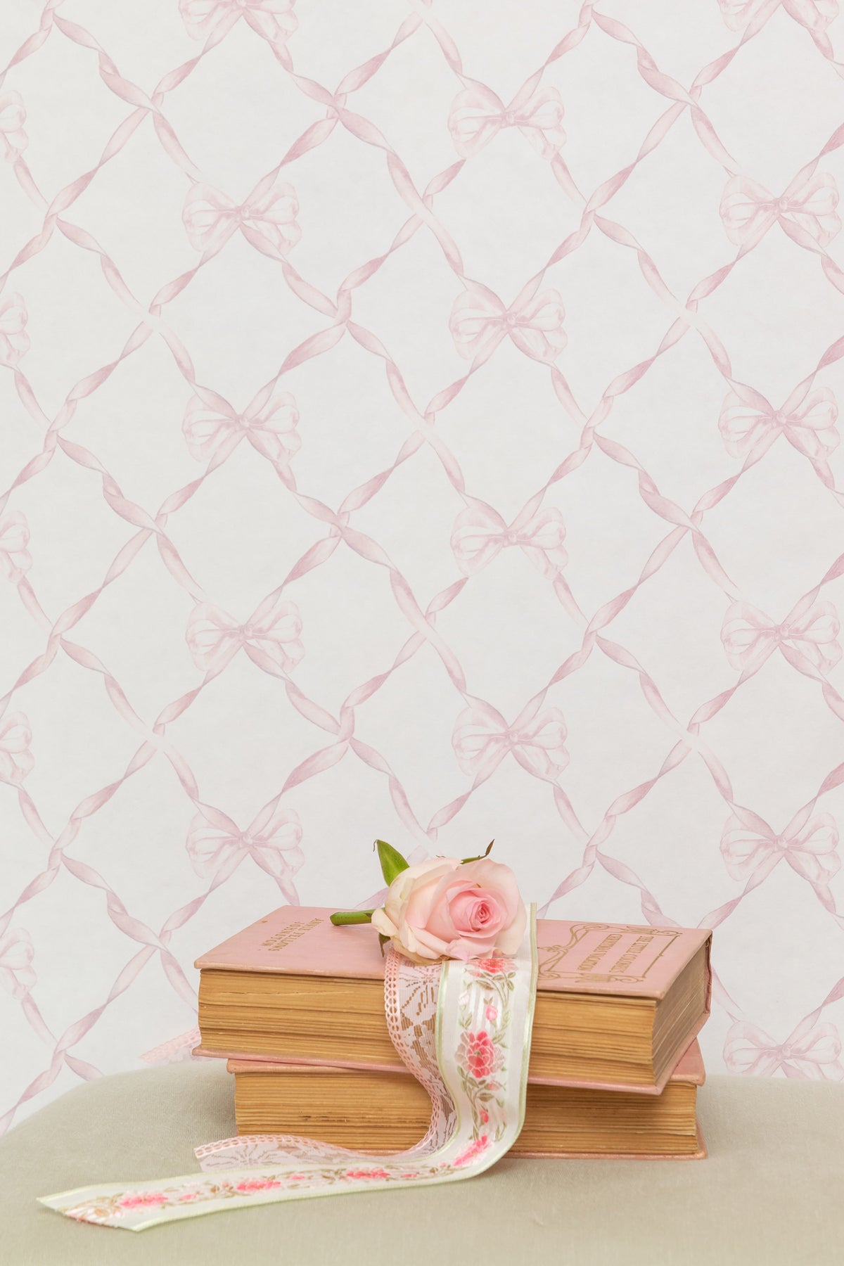 Bow-pattern wallpaper with faded primrose ribbon bows on a pale background