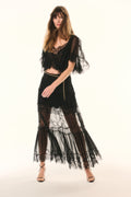 Black lace pleated maxi skirt with sheer tiers and gold chain belt detail, front view