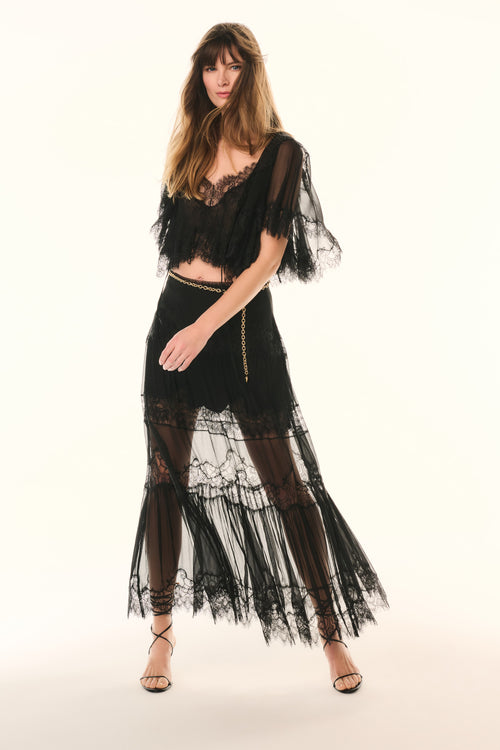 Black lace pleated maxi skirt with sheer tiers and gold chain belt detail, front view