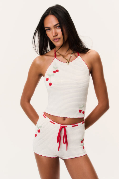 White crochet mini shorts with red tie detail and cherry print accents