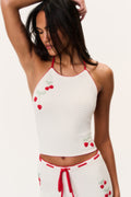 White crochet halter top with red scalloped trim and cherry appliques along front