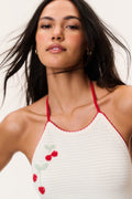 Crochet halter neckline with red ribbon ties and cherry appliques on white fabric