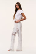 Optic white patchwork lace flared pants, side view with textured lace trim