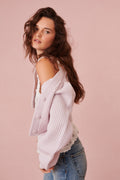 Light pink ribbed cropped V-neck cardigan with buttons, side profile