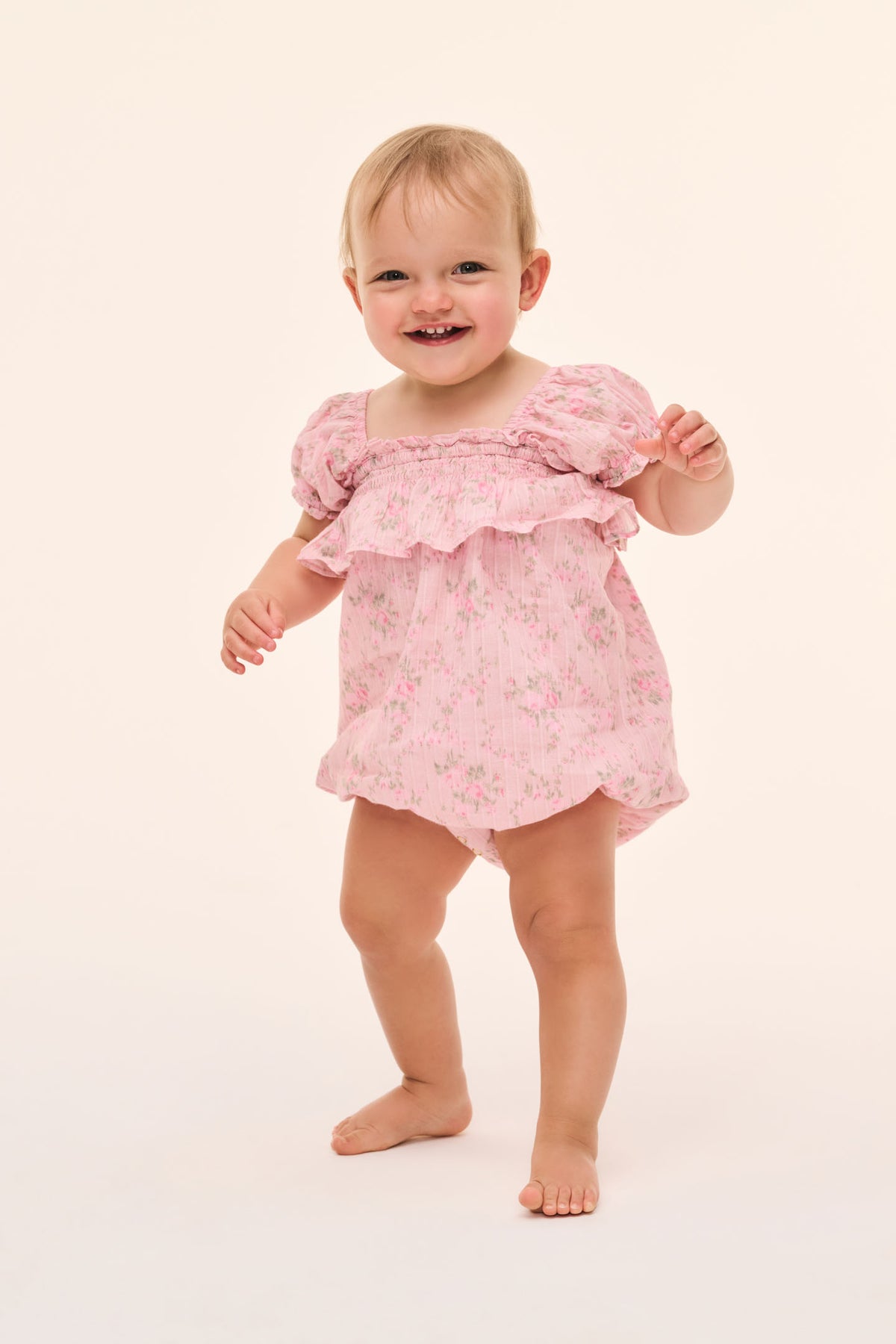 Baby pink floral pinafore with ruffle sleeves and gathered bib
