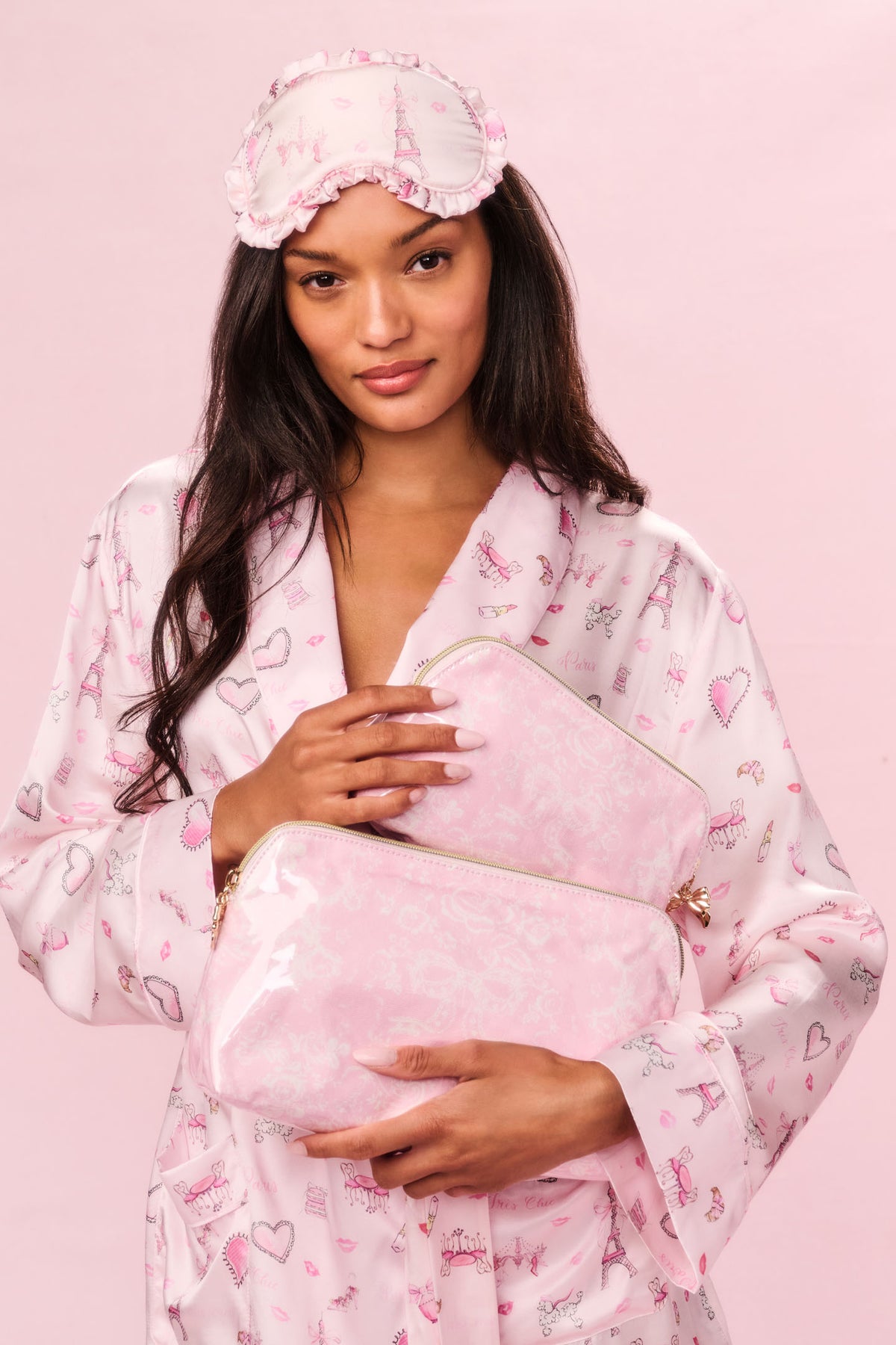 Pink toile print medium travel pouch with zipper, held by model