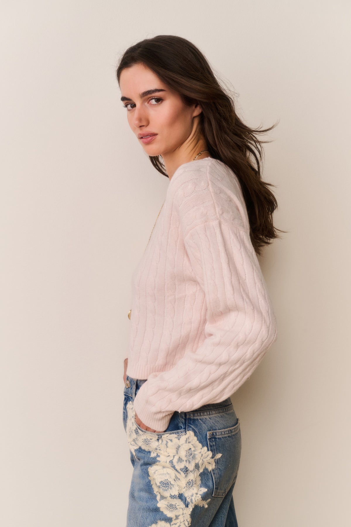 Cropped pale pink cable knit pullover sweater shown from the side