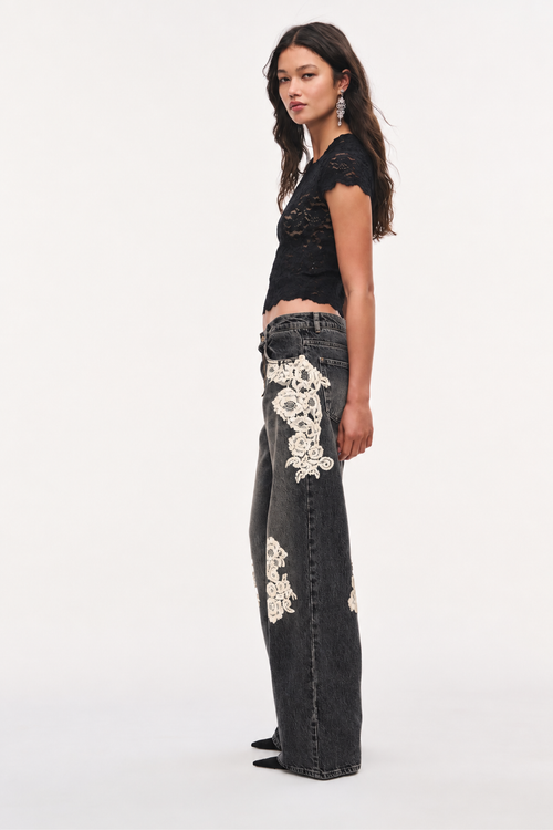 Wide-leg jeans with white floral lace appliqué in dark wash