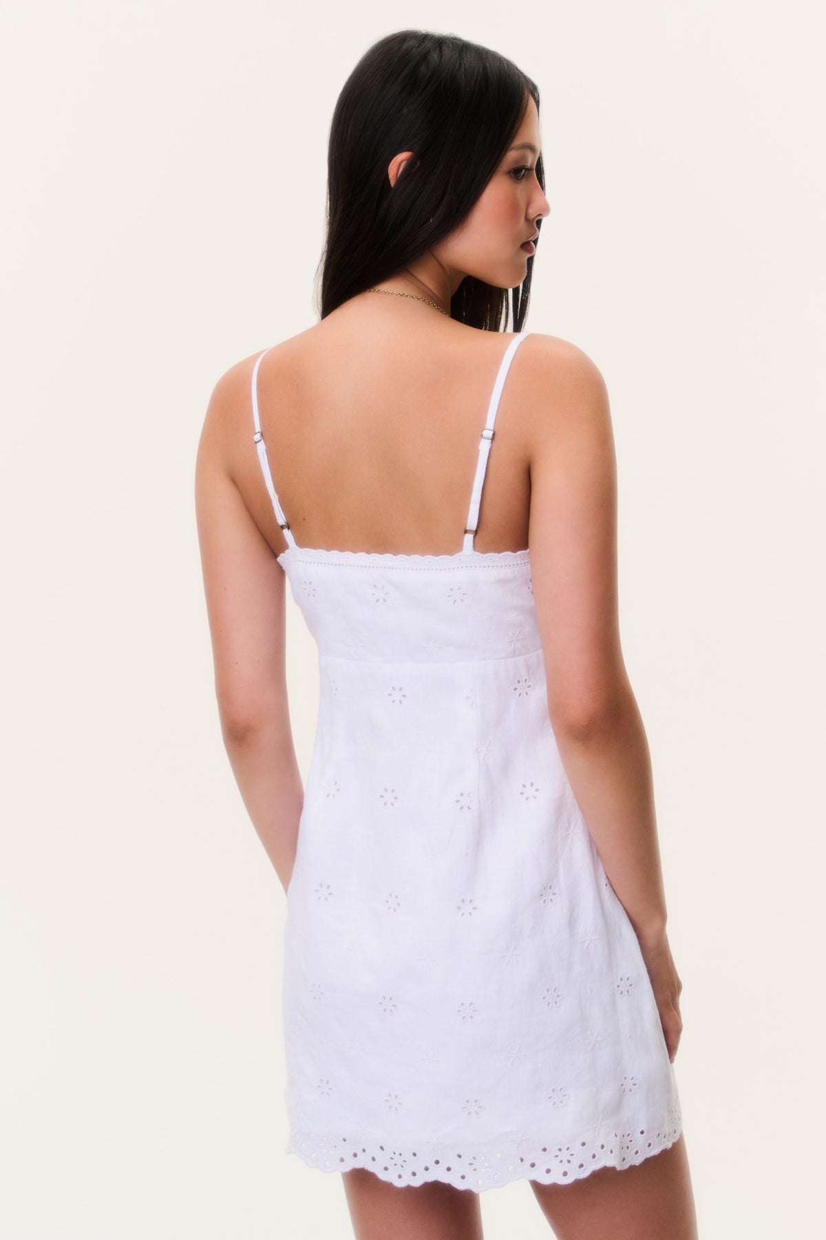 Back view of rose drift eyelet linen mini dress with spaghetti straps and lace hem