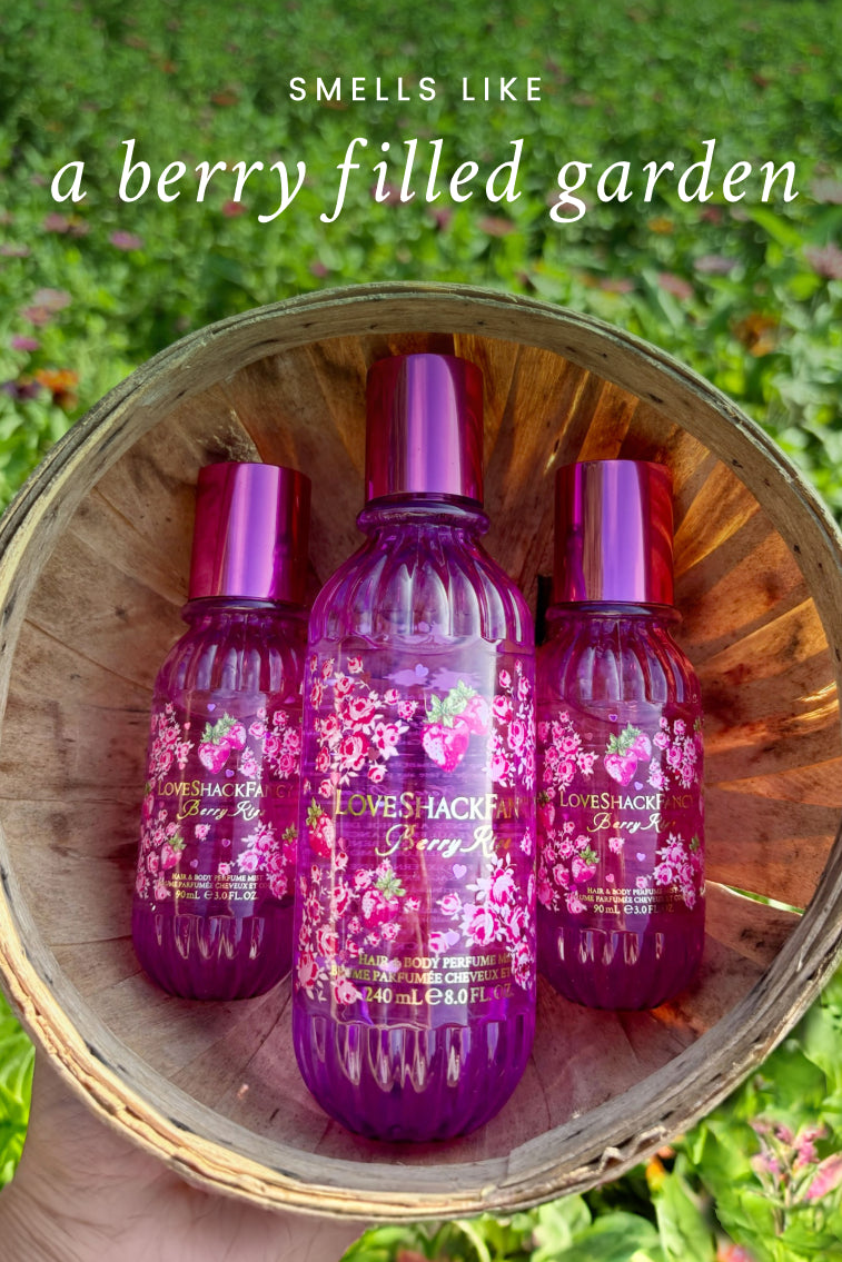 Three Berry Kiss perfume mist bottles, purple-toned with metallic caps