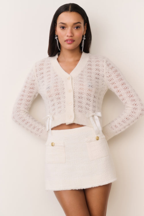 Cream tweed mini skirt with gold buttons and short A-line silhouette