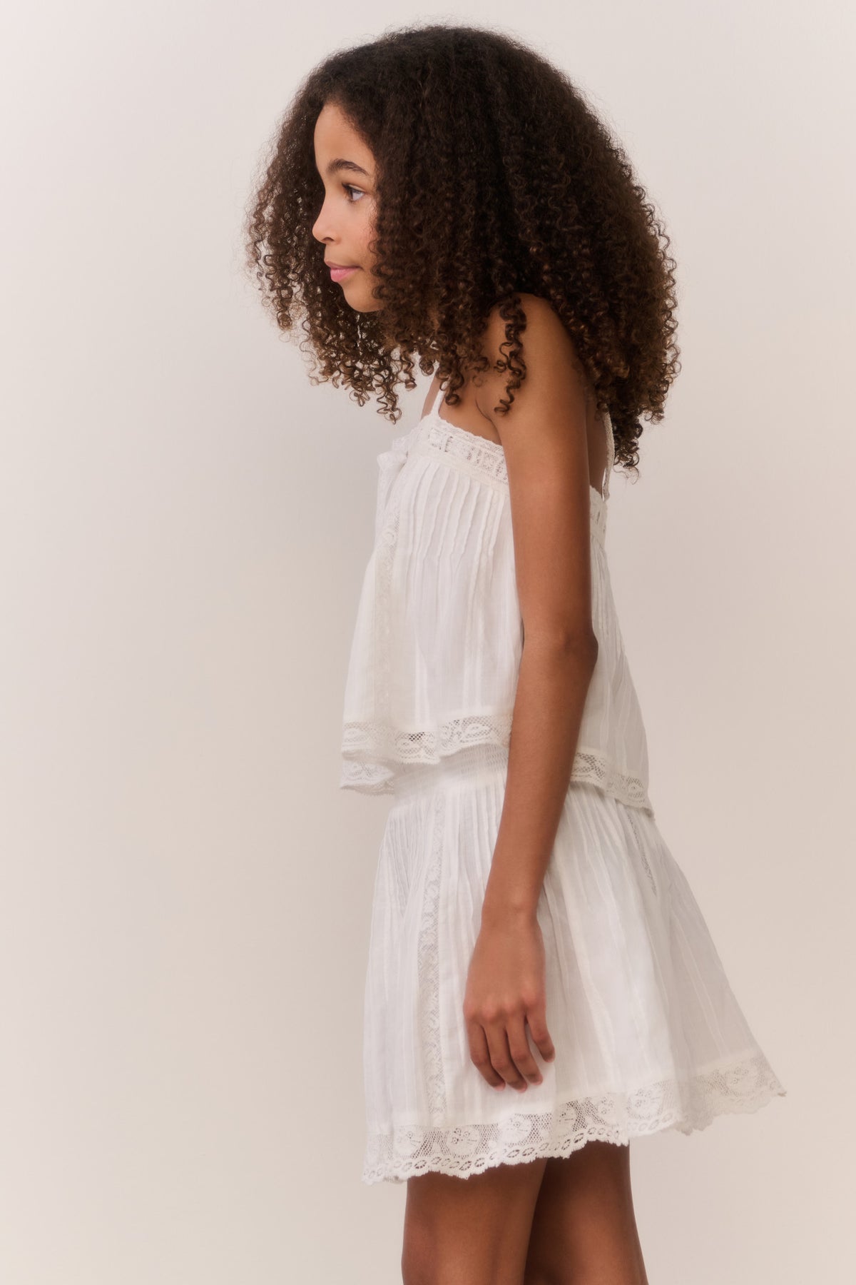 White cotton tween sleeveless top with spaghetti straps and tiered ruffle hem